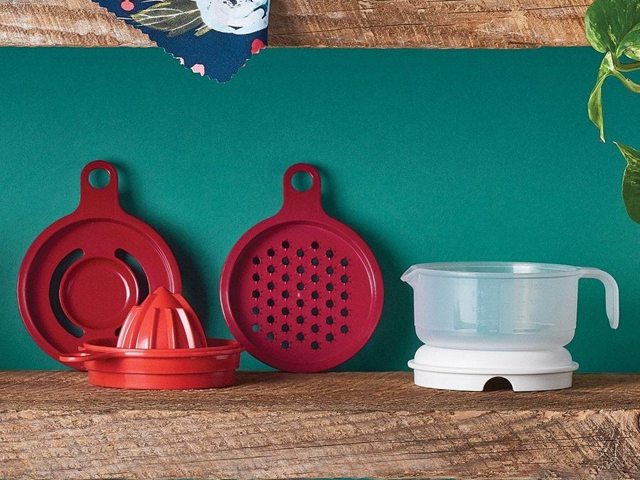 tupperware all in one mate red with juicer, zester and egg separator on green background